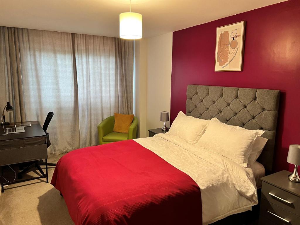 布赖尔利希尔Spacious 1 bed relocation apartment free parking,的卧室设有红色墙壁、一张床和一张书桌