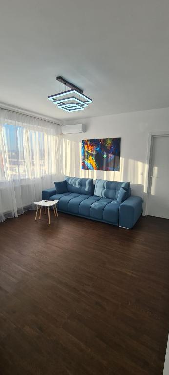 德瓦Belvedere Delux Apartment的客厅配有蓝色的沙发和桌子