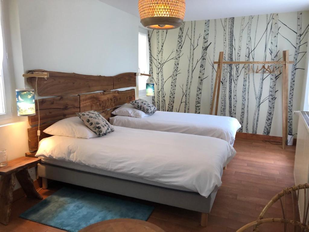 贝尔热拉克Chambres & Tables d'Hôtes L'Ostal de Pombonne的一间卧室设有两张床,墙上有树木