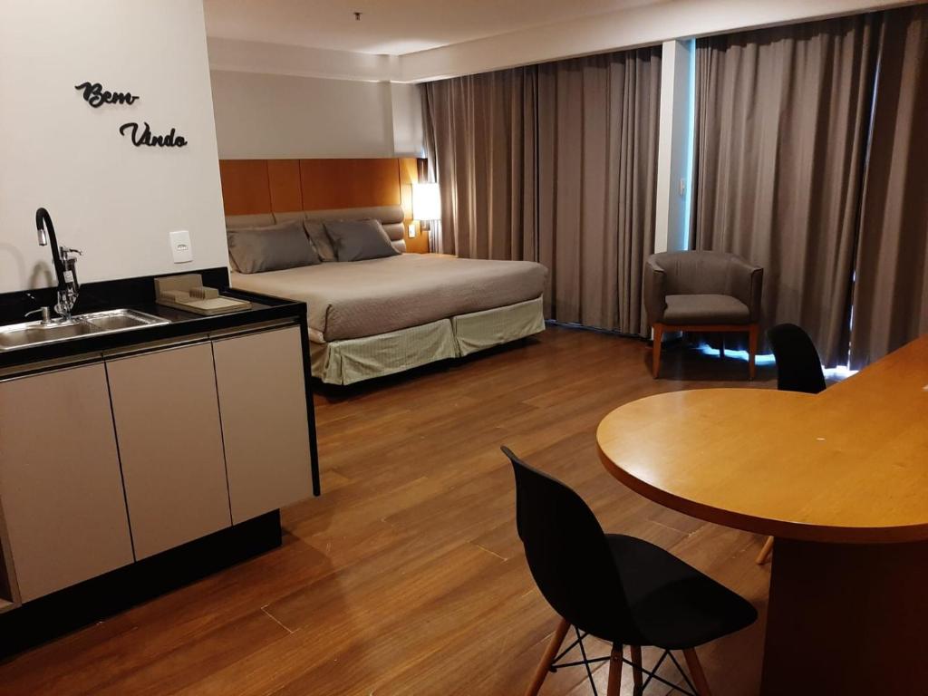 里约热内卢Botafogo Suites的酒店客房配有一张床铺和一张桌子。