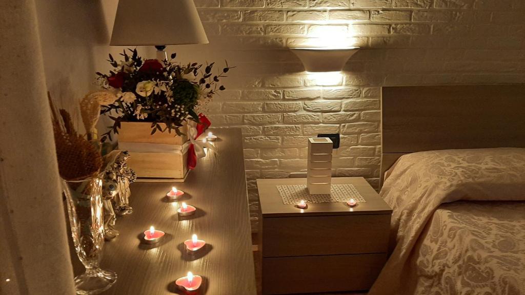 苏尔博Casa "Settima essenza"的一间设有一张床和一张带蜡烛的桌子的房间