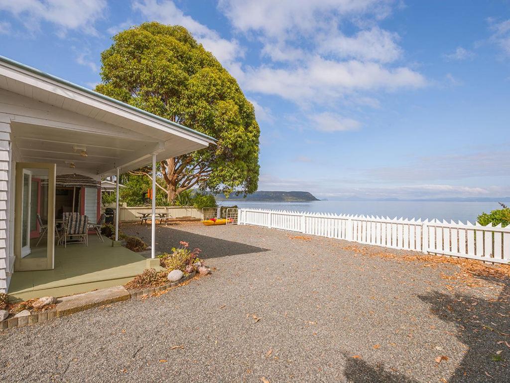 WaitahanuiLake Edge Cottage - Waitahanui Holiday Home的海边的白色围栏房子