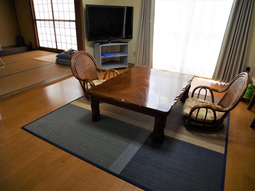 富山Guest House Inujima / Vacation STAY 3516的客厅配有木桌和椅子