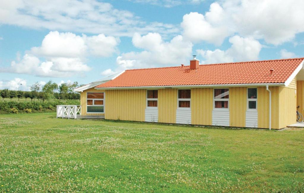 腓特烈斯科格Friedrichskoog-strandpark 3的院子里的黄色房子,有橙色的屋顶