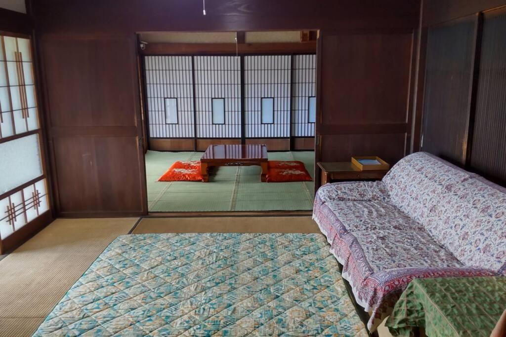 挂川市古民家リゾートハウス　ひみつきち的带两张床的房间和一个带窗户的房间