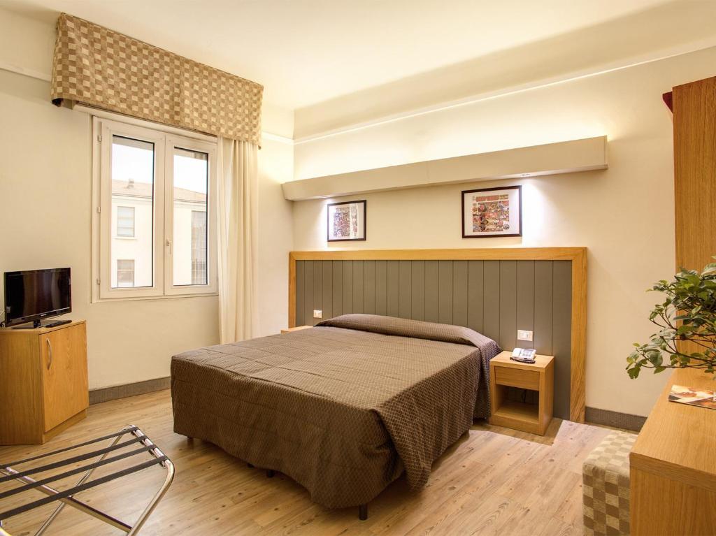 佛罗伦萨德拉纳泽欧尼酒店的酒店客房,配有床和电视