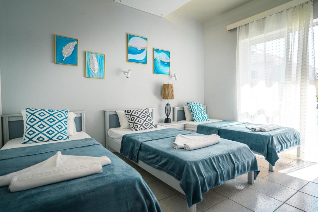 阿默达拉-伊拉克利翁RODI BLUE appartments的一间带两张床和一张沙发的卧室