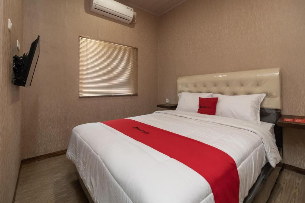 ParitRedDoorz @ Jalan Srikandi Pekanbaru的一间卧室配有一张带红色毯子的大床