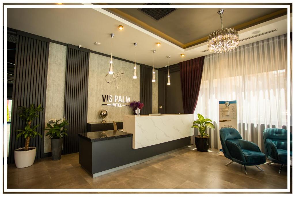 甘贾VIS Palm Hotel Ganja的大堂设有前台和2把蓝色椅子