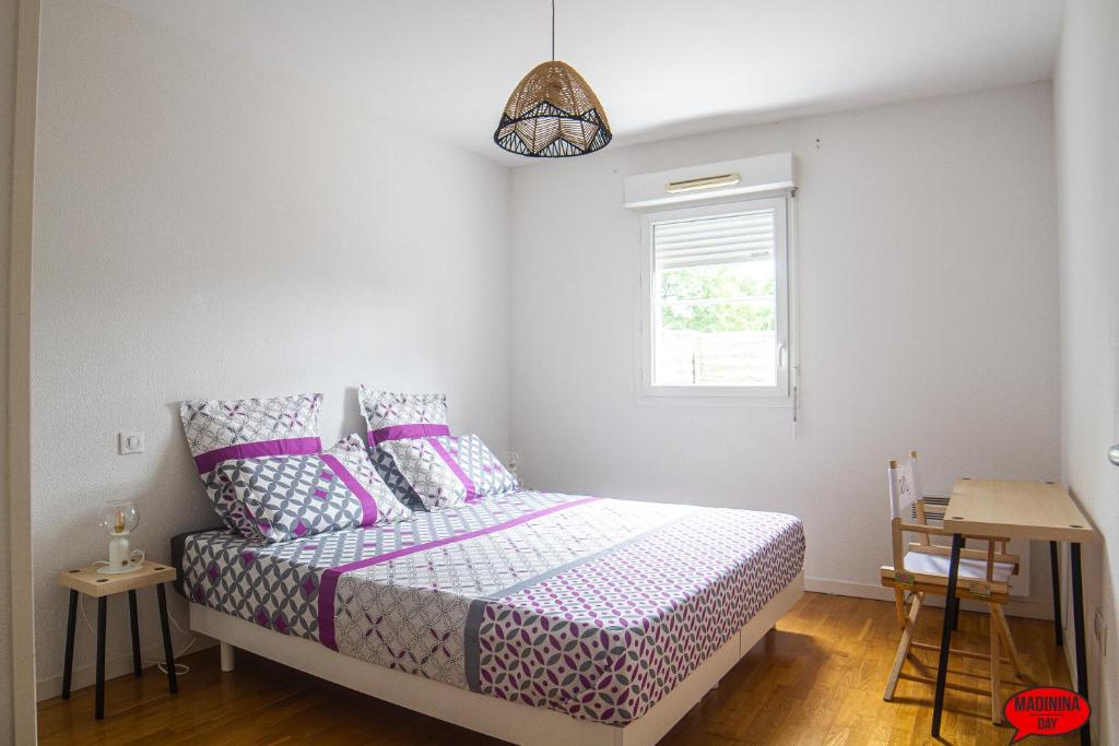 雅莱地区圣梅达尔MADININA DAY的一间卧室配有一张带紫色床单的床和窗户。