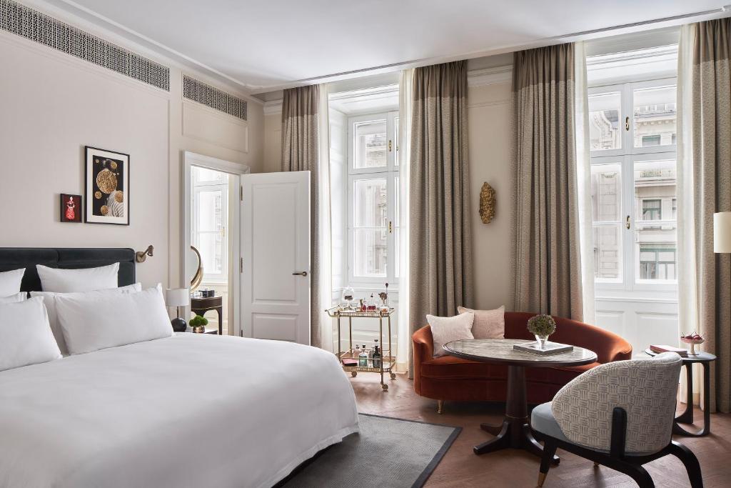 维也纳Rosewood Vienna的卧室配有1张床、1张桌子和1把椅子