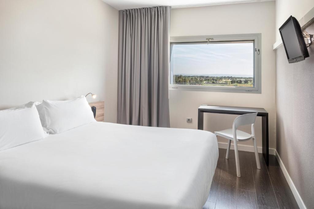 阿尔巴塞特B&B HOTEL Albacete的配有一张床、一张书桌和一扇窗户的酒店客房