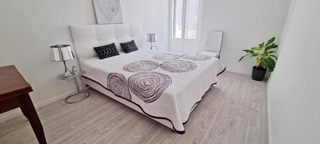 的里雅斯特Casa Bianca - 2 Bedroom Design Apartment的一间卧室配有一张带白色床罩的大床