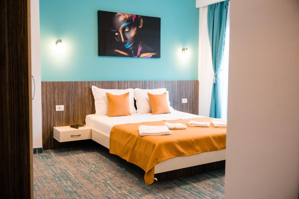 北马马亚-讷沃达里Vila GRANDE MAMAIA NORD的酒店客房的床铺配有橙色床单