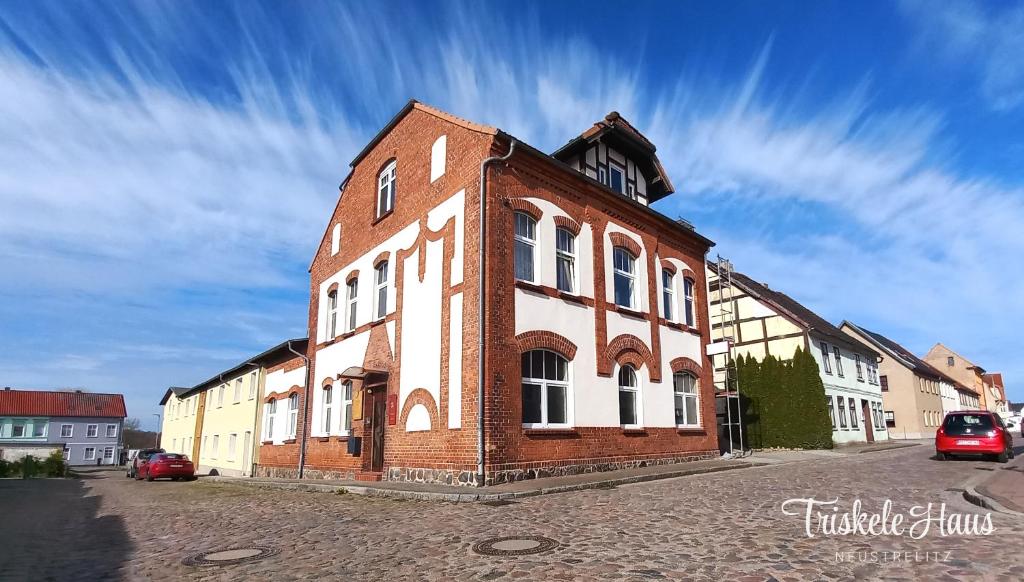 施特雷利茨Triskele Haus - Ökologisches Seminar- und Gästehaus in Strelitz的街道上一座旧砖砌的建筑,有塔楼