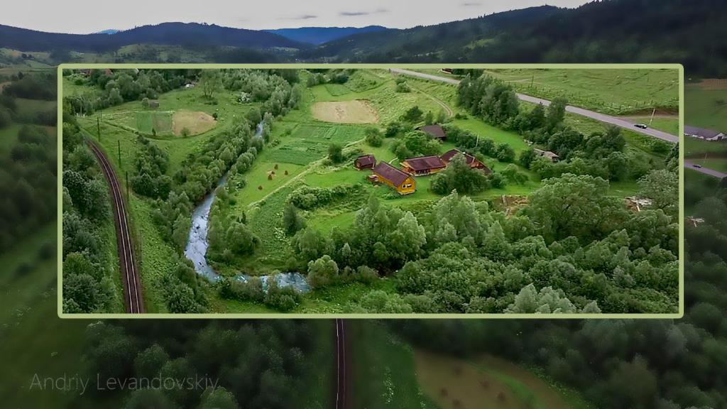 Yasenitsa ZamkovaYasna Sadyba的享有农场的空中景色,拥有房子和河流