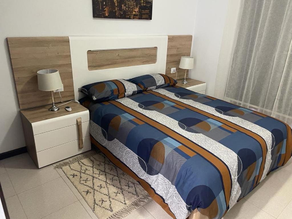 圣米格尔德阿沃纳Vacacional Arbelo Golf的卧室内的一张床位,配有2个床头柜和2盏灯