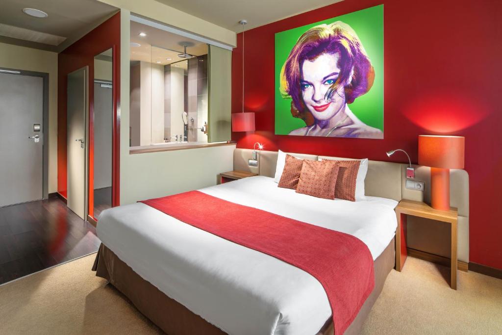 布拉迪斯拉发Clarion Congress Hotel Bratislava的卧室配有一张大床,墙上挂有绘画作品
