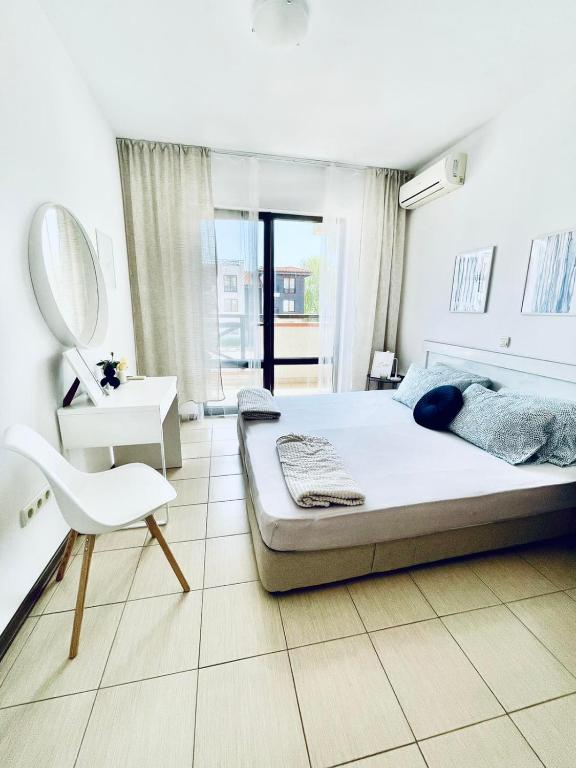 切尔诺莫雷茨Апартамент в комплекс Свети Никола плаж Градина的一间卧室配有一张床、镜子和椅子