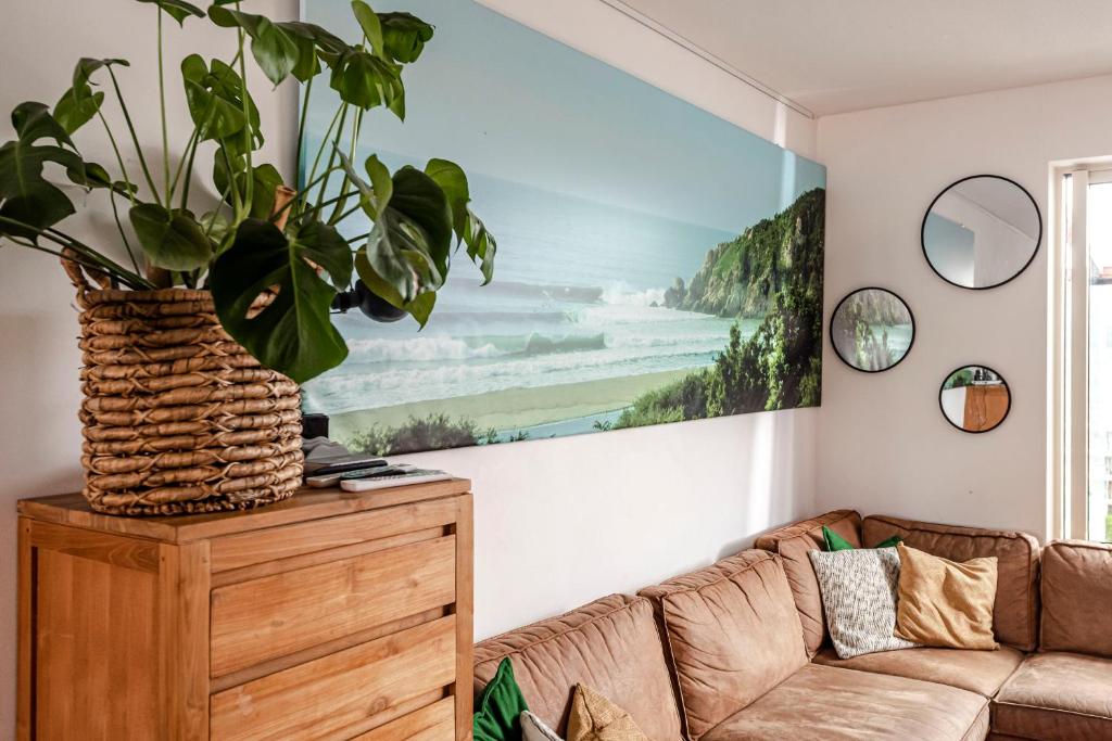 斯海弗宁恩FamilyHome near the Ocean的客厅配有沙发和墙上的绘画