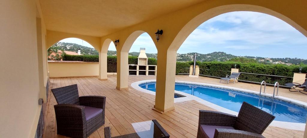 比德雷雷斯LA VILLA DEL PARAISO的一个带游泳池、两把椅子和一个游泳池的庭院