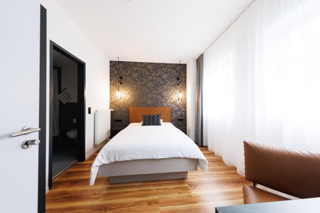 斯图加特国际学生旅馆的一间卧室设有一张床和一面墙