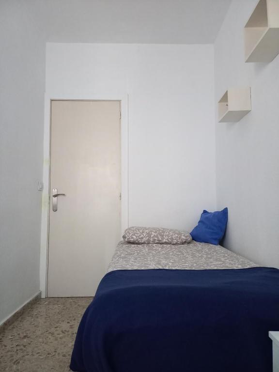 圣克鲁斯-德特内里费habitación en el centro的一间卧室设有蓝色的床和白色的门