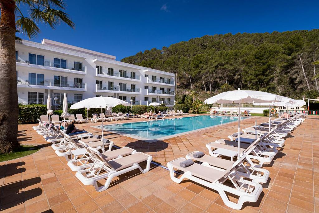 圣米格尔港巴兰萨特度假村的酒店旁的游泳池配有椅子和遮阳伞