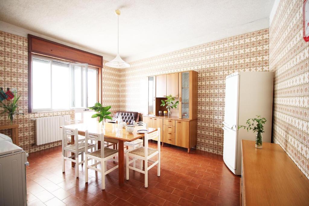 新福卡Villa Claudio by RENTHOUSESALENTO的厨房以及带桌子和冰箱的用餐室