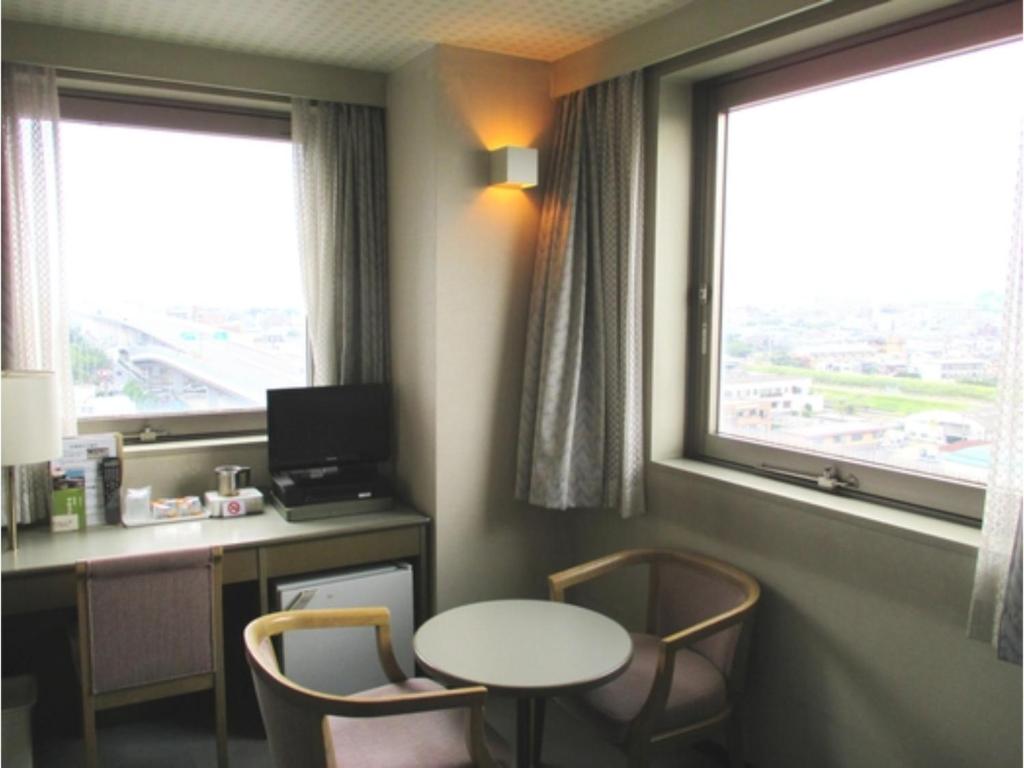 京都Pulsesin in Kyoto - Vacation STAY 73544v的客房设有书桌、桌子和2扇窗户。