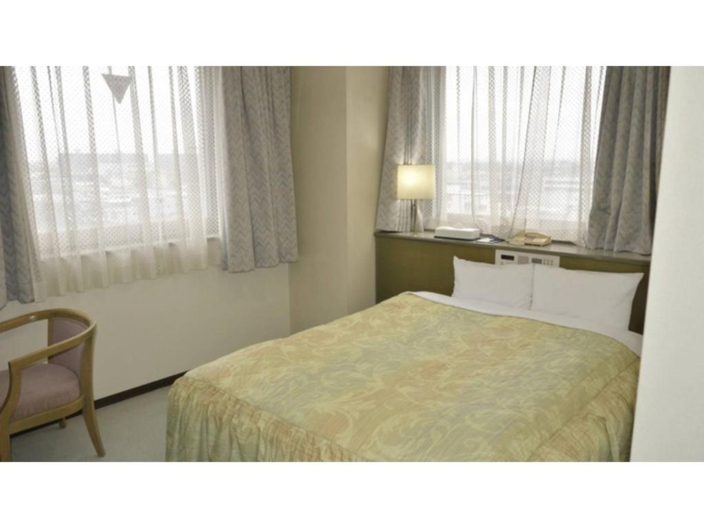 京都Pulsesin in Kyoto - Vacation STAY 73552v的一间卧室配有一张床、一把椅子和窗户。