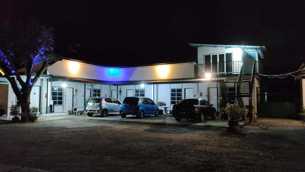 巴西富地Aleesa Roomstay的一座有汽车在晚上停在停车场的建筑