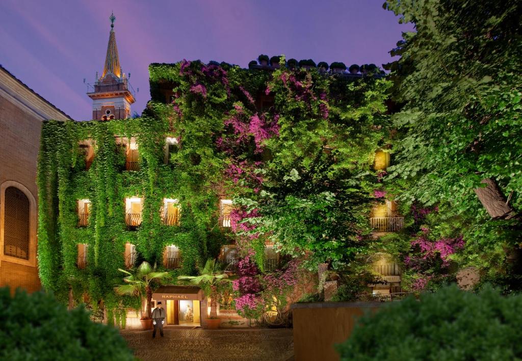 罗马Bio Hotel Raphael - Relais & Châteaux的一座被绿色常春藤覆盖的建筑,有钟楼