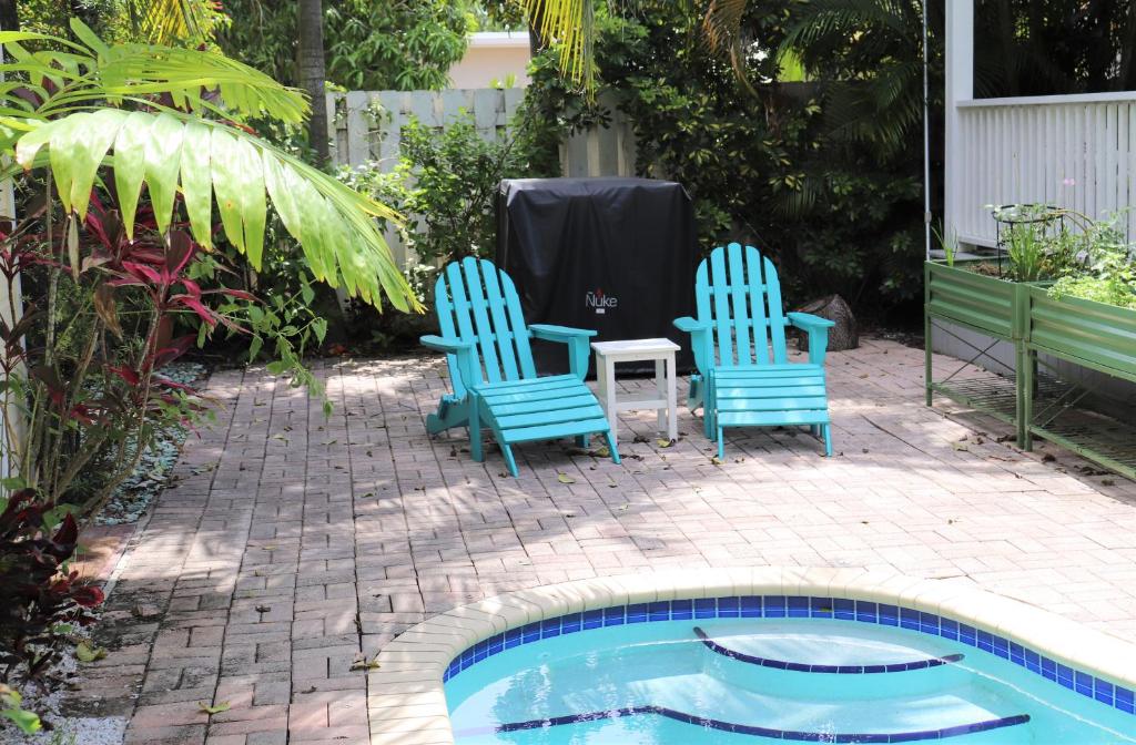 迈阿密Upper East Side Oasis的游泳池畔的两把椅子和一张桌子