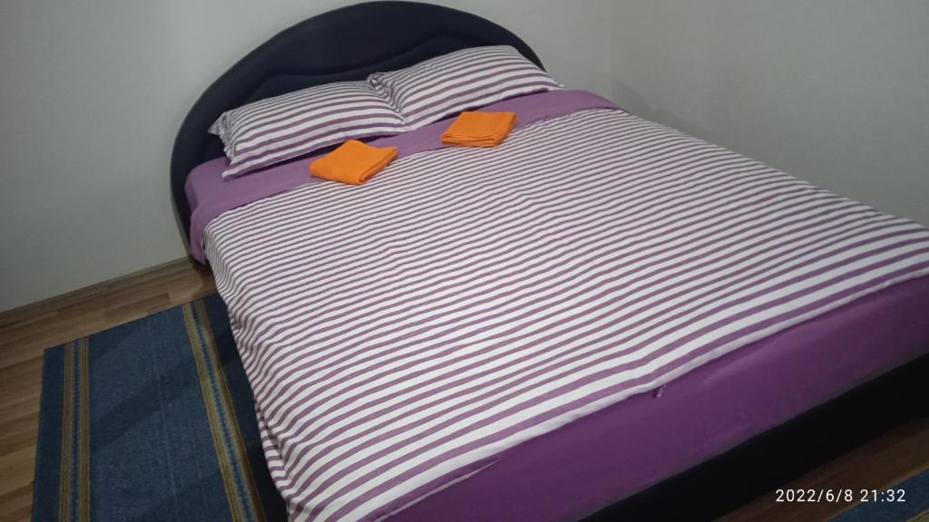 JablanicaVia Dinarica GuestHouse的一张床上有两张橙色的卡片