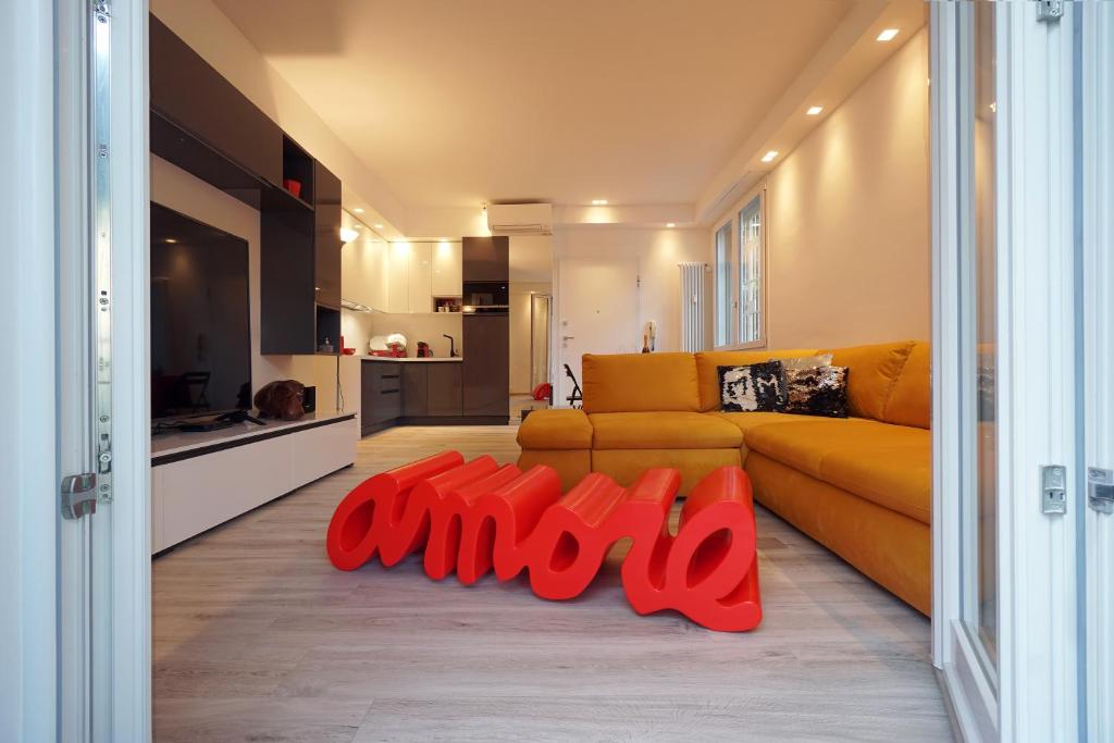 博洛尼亚Ghisello Luxury Guesthouse的客厅配有黄色沙发和红色的物品