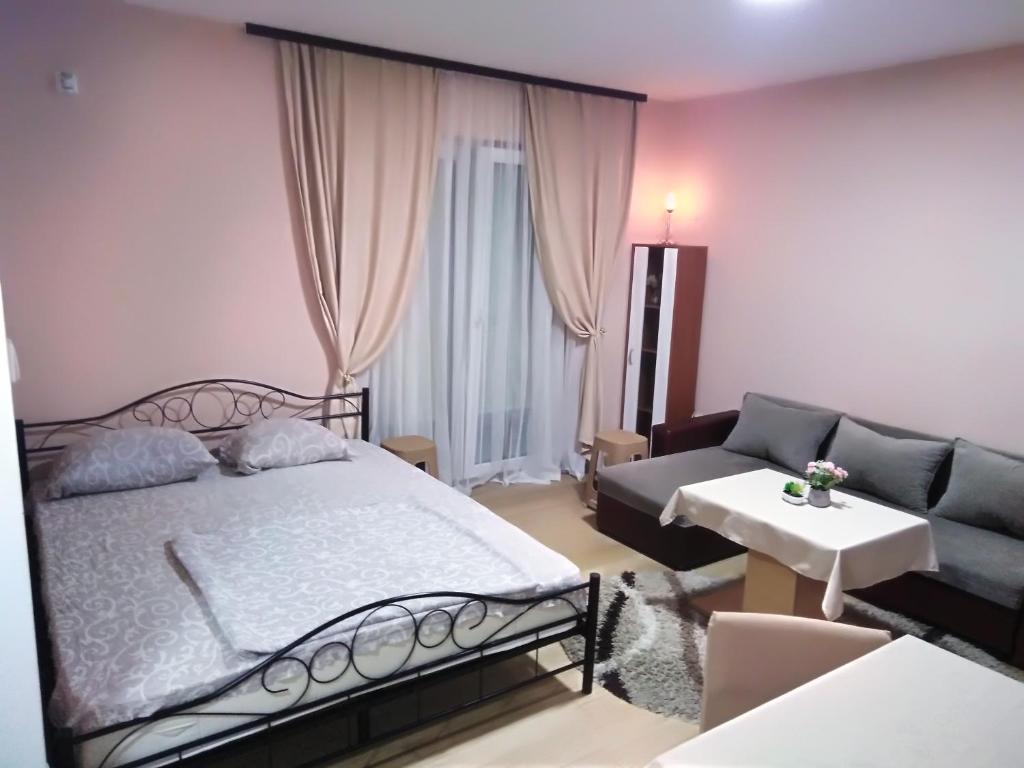 弗尔尼亚奇卡矿泉镇Apartman 1的一间卧室配有一张床和一张沙发