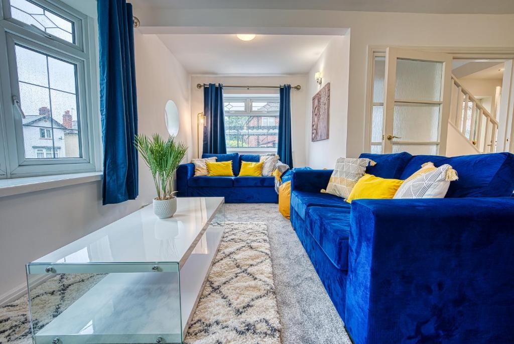 伯明翰Modern 3 Bedroom 2 Bath House with Parking by 360Midlands Wednesbury, Birmingham的客厅配有蓝色的沙发和玻璃桌
