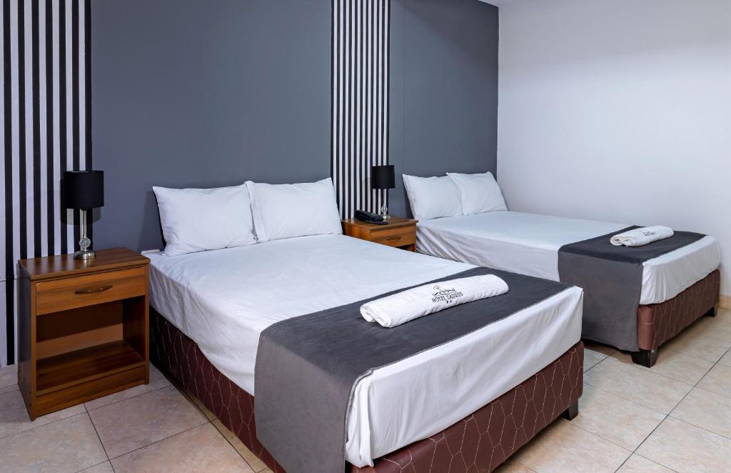 皮乌拉Hotel Taurus的酒店客房,设有两张床和两张桌子
