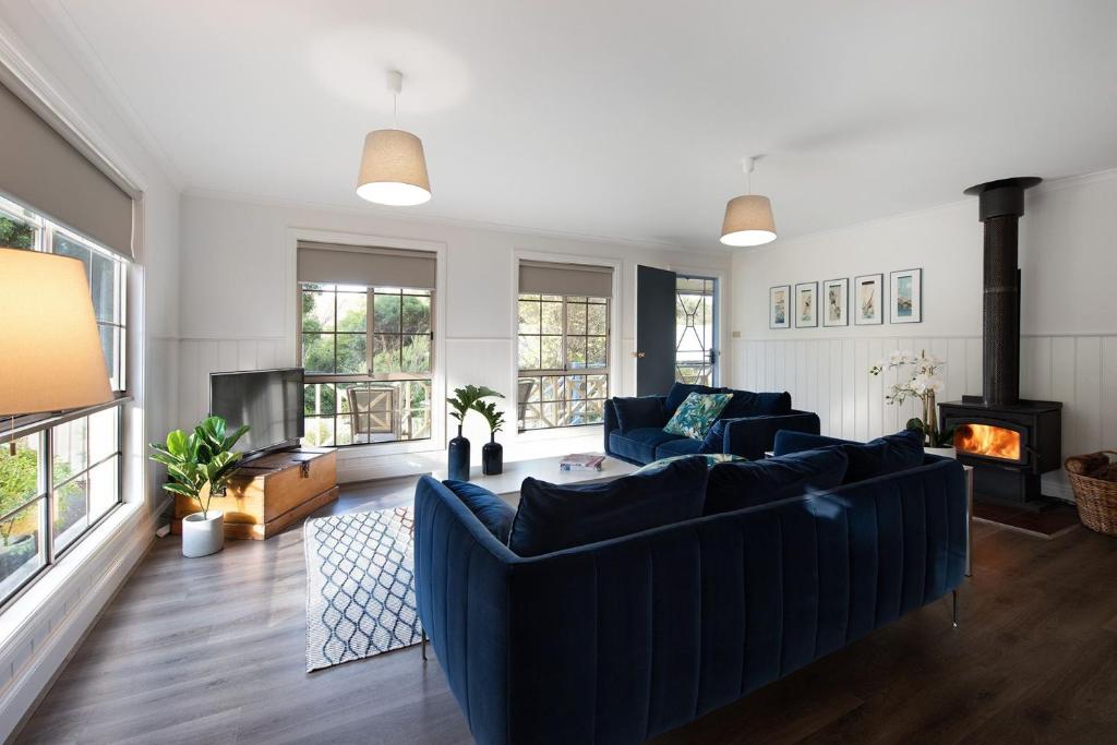 赫本温泉Springview Cottage的客厅设有蓝色的沙发和壁炉