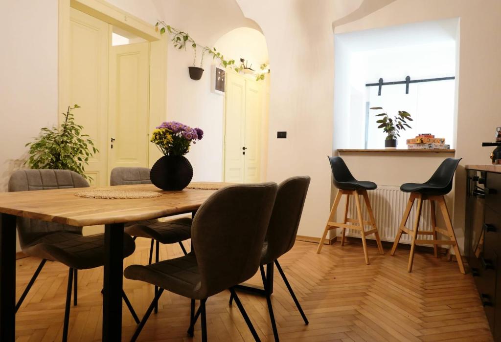 蒂米什瓦拉The Industrique Home - 3 Bedroom Apartment的餐桌、椅子和花瓶