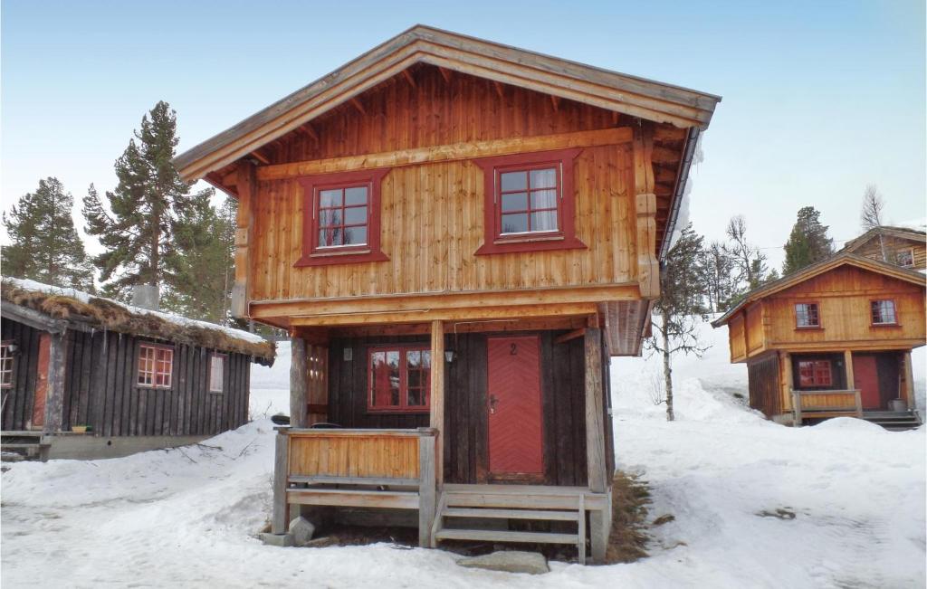 灵厄比灵厄比马萨普拉森二号度假屋的雪中带红色门的小木屋