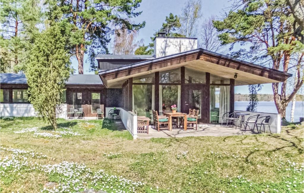 AspöAmazing Home In Strngns With House Sea View的小屋设有带桌椅的甲板