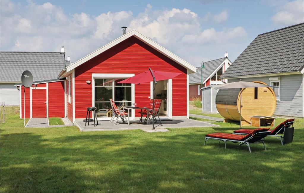 泽彭施鲁塞Cozy Home In Zerpenschleuse With Sauna的院子里的红色房子,配有桌椅