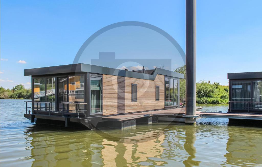 欧维恩拉克Houseboat Waterlelie的水面上浮动的房子,有玻璃 ⁇ 顶