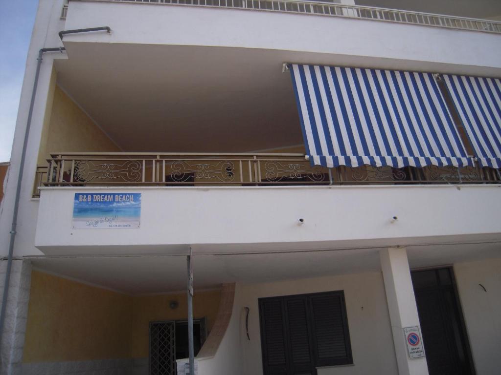 切萨雷奥港萨伦托梦想海滩住宿加早餐旅馆的一面有国旗的建筑的一侧的阳台