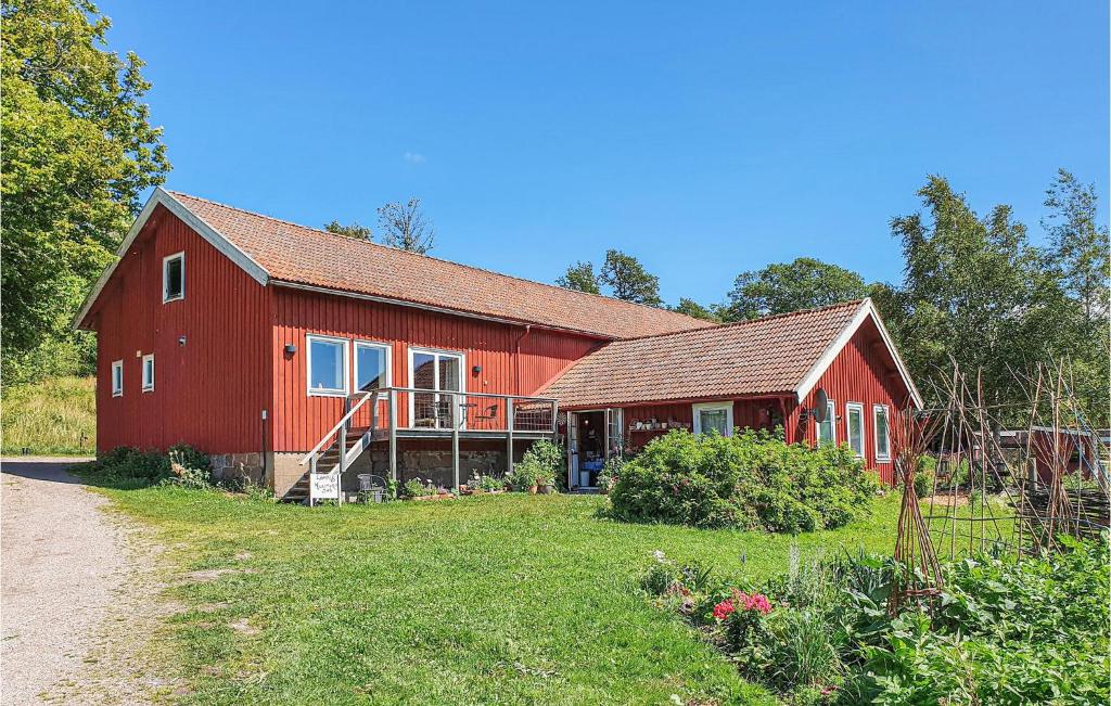 SvanesundNice Apartment In Svanesund With House Sea View的前面有一个大院子的红色谷仓