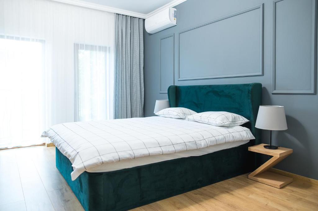 卡尔洛沃Deluxe Central Rooms的一间卧室配有一张带绿色床头板的床