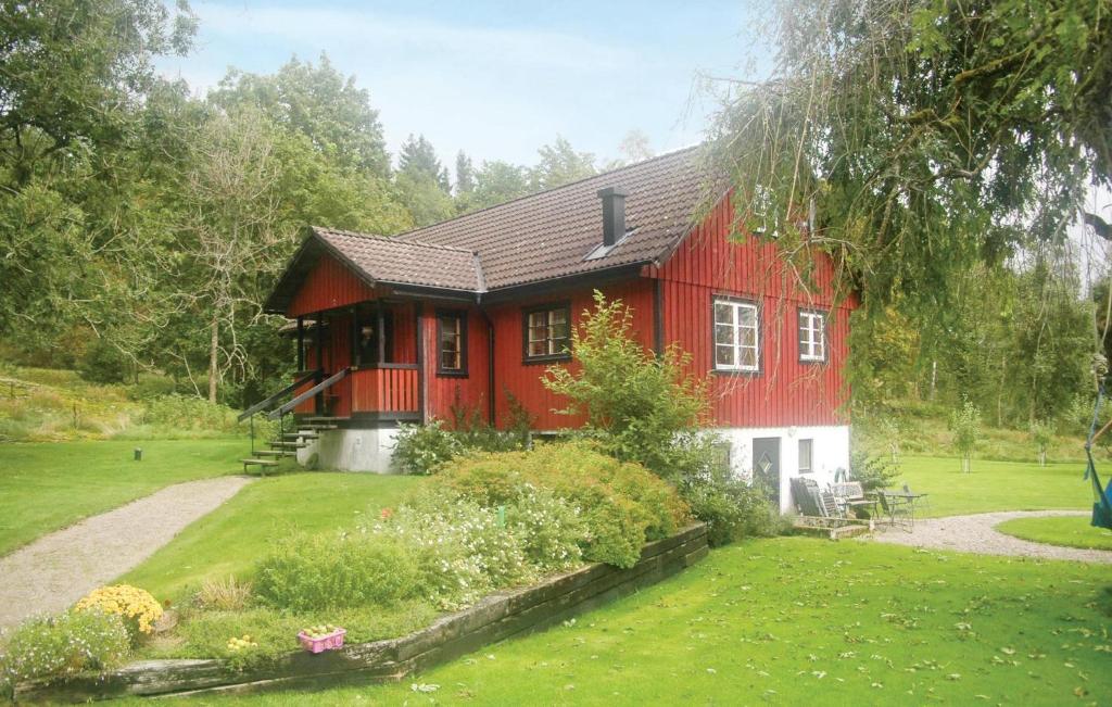 HäljebolNice Home In Uddevalla With 3 Bedrooms And Wifi的前面有花园的红色房子