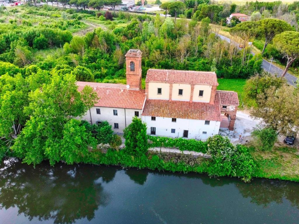 比萨-- Il Casale Toscano -- 1700mt dalla Torre di Pisa, ONLY RENTS ROOMS WITHOUT BREAKFAST, FREE PARKING, POSSIBILITÀ DI SELF CHECK-IN DALLE 15的水面上岛上房屋的空中景观